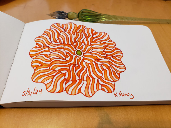 Hand drawn generative/iterative art in ink on an open page of my sketchbook. The abstract pattern is floral, and my glass dipping pen is next to my sketchbook.
