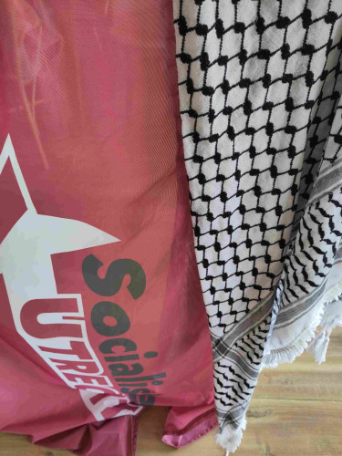 A red flag with the symbol of Socialisten Utrecht, coupled with a kuffiya, or Palestinian scarf
