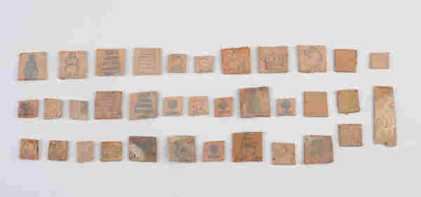 Cardboard squares lined in rows on which drawings are visible - they represent different chess pieces.