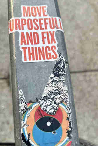 Sticker oh and Einstein and affixed to a metal bar: "move purposefully and fix things."
