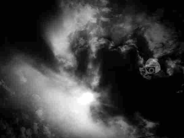 a black and white shot of dark clouds brightly backlit by the solar eclipse, which cannot be seen