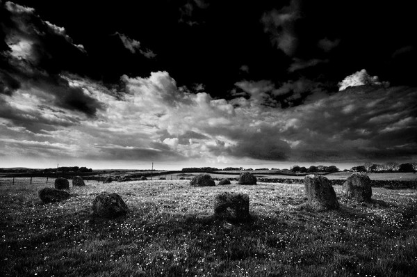 Black and white photo of a stone circle under dramatic skies.