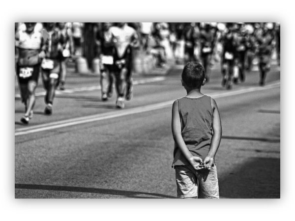 The boy watches the marathon race.