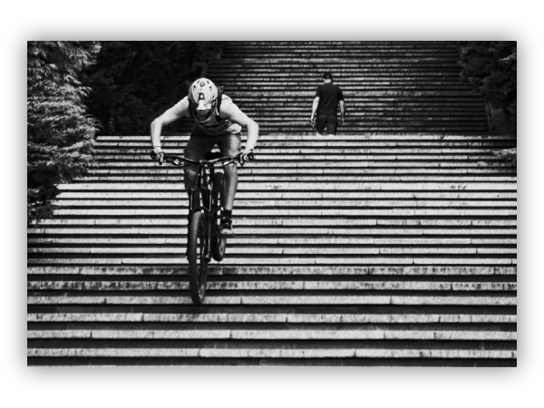 A boy riding a bicycle down the stairs.