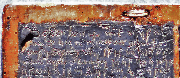 Upper part of wooden wax tablet with black wax and medieval writing.