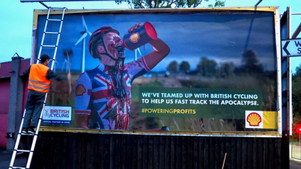 Defaced shell advert of a cyclist drinking Shell oil from a can.