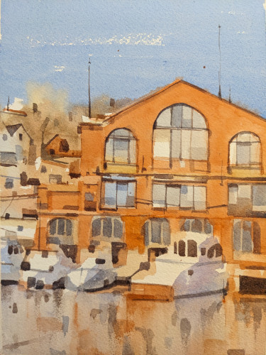 Watercolor painting of a marina along Mystic River in Mystic, Connecticut. Several white boats are parked along a dock in front of a red-orange brick building. The building is three stories tall with an angled third story. The first floor has several large bay windows along the dock. The second story has squat windows with varying shades of blue and ochre reflections in their panes. The third story has a large Arches window in the center, flanked by two smaller arches windows to its side. In the background is a mash of woods and houses below a crisp fall blue sky. In the foreground is the river, barely catching the reflection of the scene above.