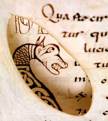Writing flows to accommodate an oval hole on one page of a manuscript, with a dragon's head visible on the page below. 