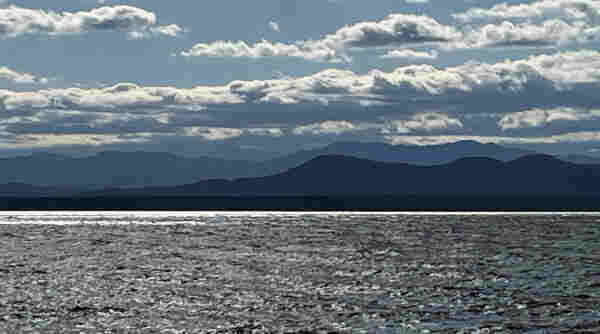 Blue world. A view of the Adirondack Mountains across Lake Champlain on a cold partly-cloudy day in the late afternoon.