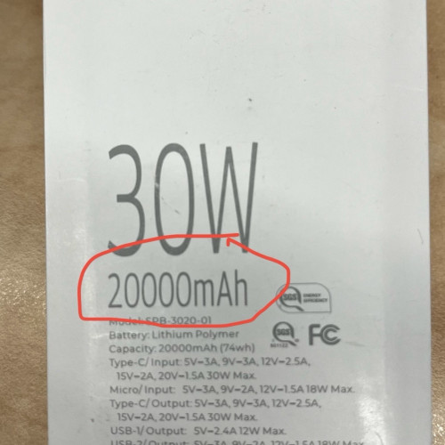 Close-up of a battery label showing "30W" and "20000mAh" circled in red, with additional specifications and certifications indicated below.