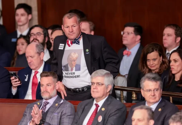Rep. Troy Nehls (R-TX) in the House chamber wearing a Donald Trump "Never Surrender" mug shot photo t-shirt, a flag bow tie, and a Laken Riley pin.