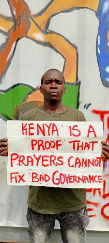 A man holding a banner reading “Kenya is a proof that prayers cannot fixed bad governance. "