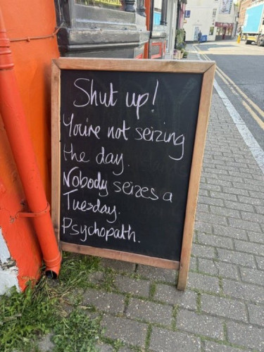 Chalkboard message outside a café.
"Shut up! You're not seizing the day. Nobody seizes a Tuesday. Psychopath."