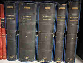 A photograph of the 5 volumes of transcripts that were smuggled to LSE Library. They have a black binding and are in blue coloured boxes. They read "Matteotti documents" along the spine. 