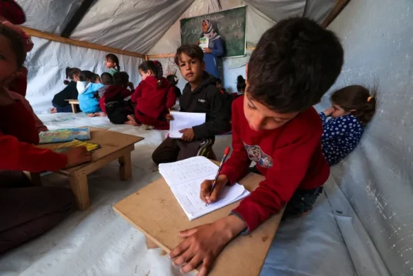 Children attend class in a makeshift classroom at a camp for displaced Palestinians in Rafah, in the southern Gaza Strip, on March 26, 2024 [Mohammed Abed/AFP]