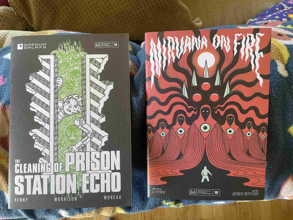 Two zines are displayed side by side. The left one is titled "The Cleaning of Prison Station Echo" and features a monochrome cover with a character surrounded by tentacle-like forms. The right one, titled "Nirvana on Fire," has a cabal of red cloaked figures looming over a much smaller figure.