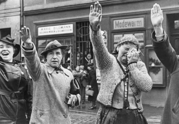 A woman in Eger, a town occupied by Germany, weeps as she salutes German troops entering to take it over from the Czechs in 1938.
Photograph: INP/Bettmann Archive