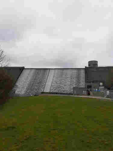 Dam  with water running down in lines of different shades of white and grey.