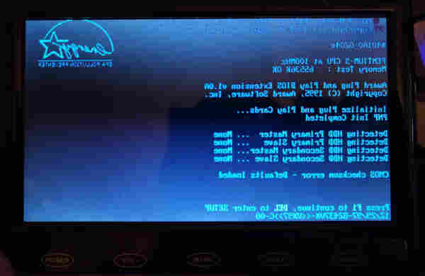 A BIOS boot screen from a Pentium PC, displayed on a small LCD screen. It's mirrored left to right. 