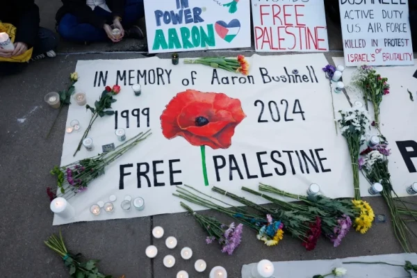 People leave notes and flowers during a vigil for US Air Force serviceman Aaron Bushnell who self-immolated outside the Israeli Embassy in Washington, DC, on Sunday to protest the war in Gaza [Anna Moneymaker/Getty Images/AFP]
A sign reads: ‘In memory of Aaron Bushnell 1999-2024’