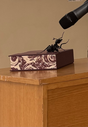 Model ant on a podium as if talking into the microphone. 