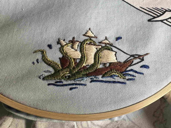 An embroidered octopus attacking a ship. The octopus is green 