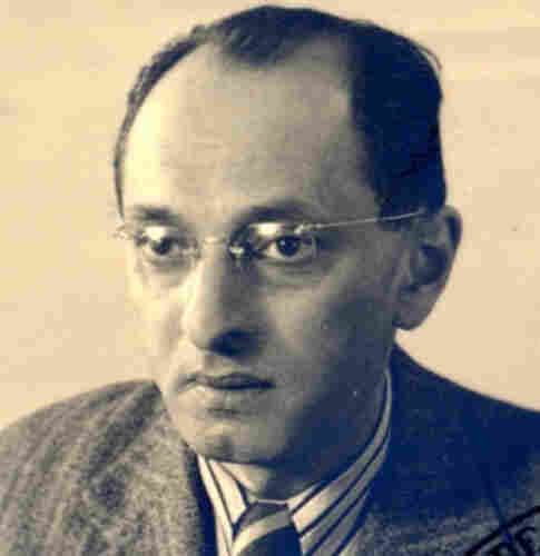 A portrait ID-style photo of a man in a jacket, shirt, and tie. He is wearing frameless glasses.