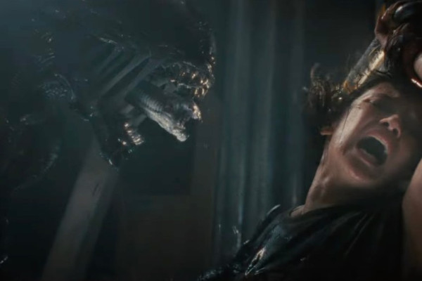 Still from Alien: Romulus, the Xenomorph and its smaller inner set of jaws is emerging towards a screaming woman