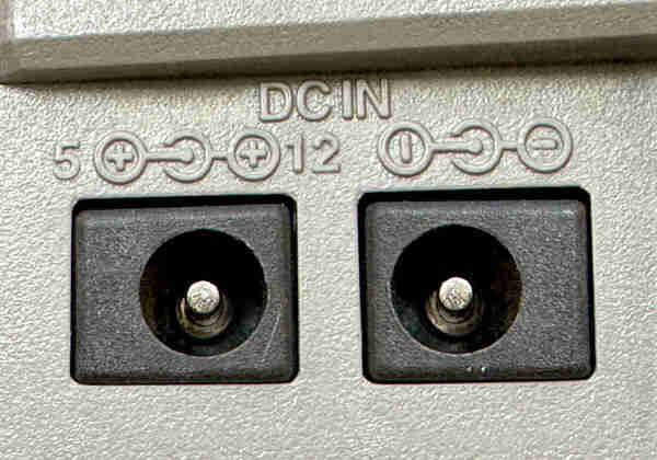A picture of a pair of barrel jack connectors marked DC IN.

One is centre and outer both positive, the other centre and outer both negative, for convenience.