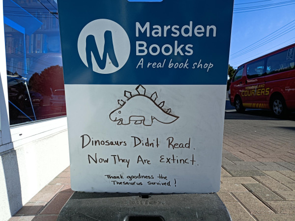 An outdoor sign reading, 'Dinosaurs didn't read. Now they are extinct.'