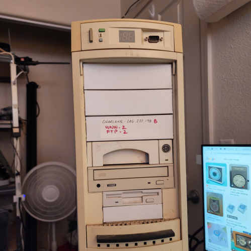 An AT tower, with the door opened. There's a 3.5" drive, a CD-ROM drive, and a removable hard drive caddy.
There's also a label on it saying "Charlene 206.237.198.8, www-2, ftp-2" 