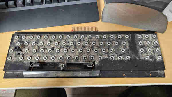 Commodore PET 8032 keyboard with all of the keycaps removed, revealing an absolutely disgusting amount of grime. 