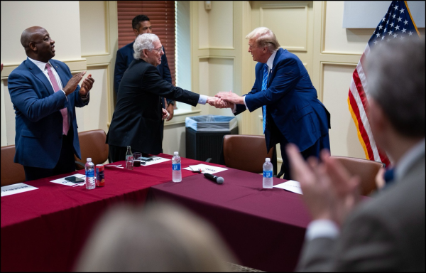 Trump is greeted by Senate Minority Leader Mitch McConnell of Ky. and Sen. Tim Scott, R-S.C., as he enters the room to meet with Senate GOP members at the National Republican Senatorial Committee.