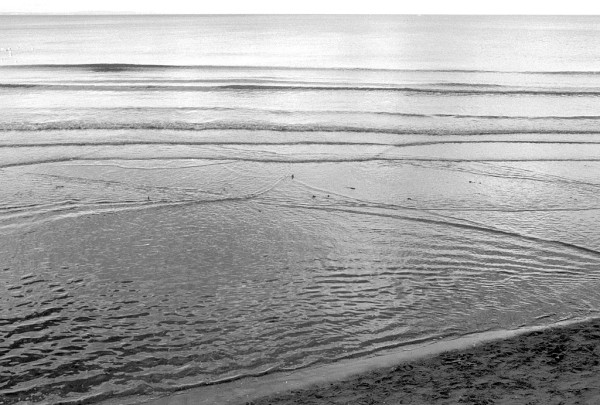 Black and white photo of ripples and very small waves in the see, nothing else. HP5.