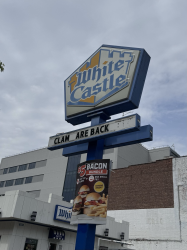 The sign on the white castle says “clam are back”