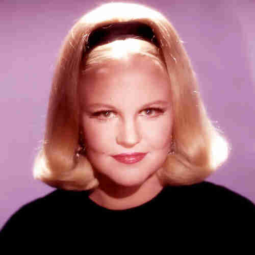 Peggy Lee - a soft-focus head-and-shoulders portrait of the singer - blonde hair with Alice band and black top. She looks piercingly at the camera with a half-smile.