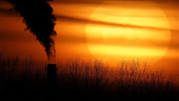 Emissions spew from a coal-fired power plant in Missouri, USA, silhouetted against a sunset. (AP Photo/Charlie Riedel)