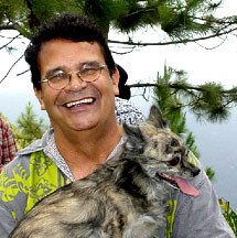 Williamson in an undated photo. He is wearing glasses, thick curly brown hair, laughing, with a dog on his lap. By Unknown - Published on the Byles Family Tree website here., Fair use, https://en.wikipedia.org/w/index.php?curid=48894144