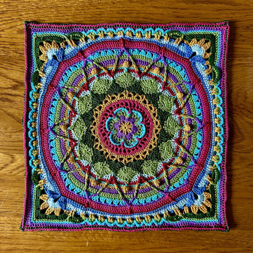 A crocheted square. It’s a brightly coloured mandala. 
