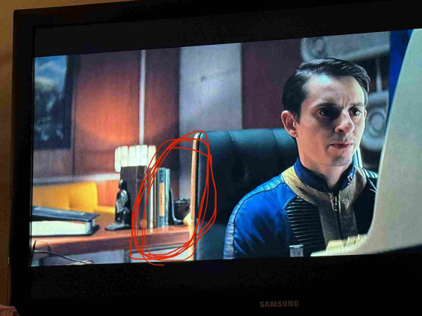 Screenshot from Fallout Tv series with red circle around Modern Library book