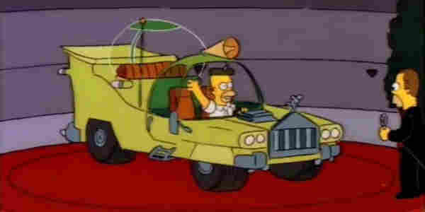Scene from the Simpsons episode, “Oh Brother, Where Art Thou?” In which Homer appears behind the wheel of a car he designed for his long-lost brother’s automobile company. The car is a monstrosity of moronic design.