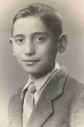 Portrait photograph of a young boy wearing a jacket, and a wide-striped tie. His ears are slightly protruding. His hair is short. He is looking straight into the camera.