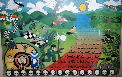 Colorful mural of the massacre at the Sumpul River made by the survivors and family members of the victims, on display in Arcatao, Chalatenango, El Salvador. Shows a soldier with an M16 kneeling by the river, which is red and full of black human corpses. On the hillside behind him, children and families are being shot at by soldiers. Skulls line the bottom of the mural. By Elhesinberg - Own work, CC BY-SA 4.0, https://commons.wikimedia.org/w/index.php?curid=106983490