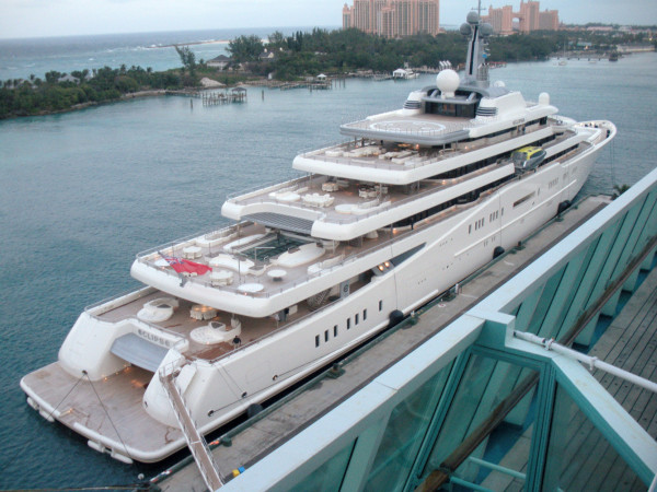 a huge motor-driven luxury yacht with a swimming pool, helipad, seating areas etc.