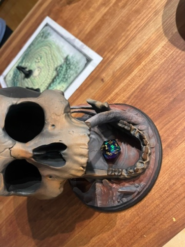 D20 shows a 2 in skull dice tower sitting on a table.
