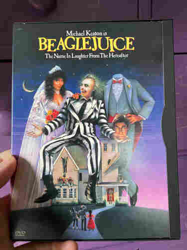 me holding the dvd case to beetlejuice in front of a purple dresser but i edited "beetlejuice" to say "beaglejuice" 