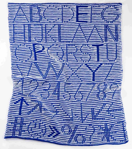 a blue and white striped blanket with the alphabet, numbers, and simple symbols knitted into it