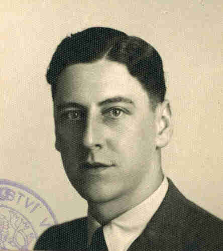 Portrait photo for a document. A young man with short, closely cropped hair parted on the left side of his head. He is wearing a jacket, shirt and tie. Look straight into the lens, left part of the face illuminated, right part in slight shadow.