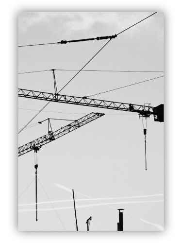 Cranes, high-voltage lines, chimneys, contrails.  Contrast.