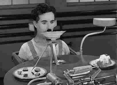 Scene from Charlie Chaplin's Modern Times made in 1936, where he's the test subject for a lunch machine being fed soup and corn from a rotating table
